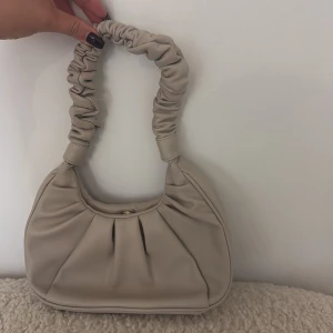Beige handväska med rynkad axelrem - Snygg beige handväska med mjuk, rynkad axelrem och rundad form. 🌸