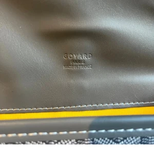 Snygg svart axelväska  - Snygg svart axelväska med ikoniskt mönster och vita detaljer. Väskan har justerbar rem, lock med spänne och klassisk G-logga. Tillverkad i skinn och canvas, perfekt för dig som vill ha något exklusivt och stilrent.