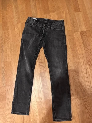 Svarta slim jeans från Jack and Jones  - Säljer ett par svarta jeans med slim passform och klassisk femficksdesign. Jeansen har en diskret tvättad look och är tillverkade i ett mjukt denimtyg. Perfekta till en avslappnad stil och funkar året runt. Kom privat för mer frågor! 😁