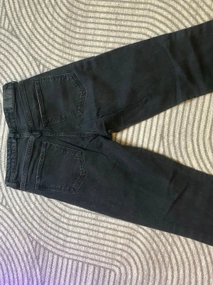 Svarta utfall jeans från Gina - Säljer ett par svarta utfall jeans från Gina med klassisk femficksmodell och hög midja. Jeansen har smal passform och är tillverkade i stretchigt denimtyg för extra komfort. Perfekta för en clean och stilren look. Ganska mörkgrå i färgen. Köpt för 500kr säljer för 250
