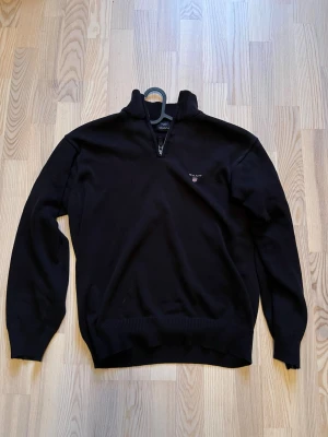 Mörkblå Gant tröja - Mörkblå quarter zip tröja från Gant. Sparsamt använd och i ett extremt bra skick. Skicka ett meddelande vid frågor! 