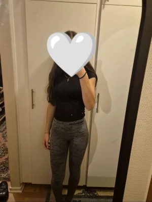 Gråmelerade gråa träningstights - Säljer ett par gråa träningstights med hög midja och tight passform. De är stretchiga och bekväma, perfekta för att chilla eller träna i. Materialet känns mjukt mot huden och de har en enkel, stilren look utan synliga detaljer. Passar xs-m! 