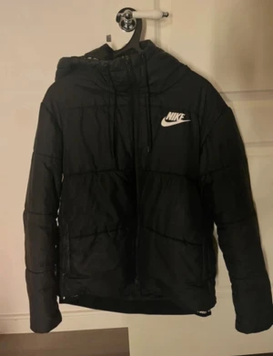 Svart vinterjacka från Nike - Vinterjacka från Nike i storlek L. Använt men fint skick, lite sminkfläckar på insida krage se bild