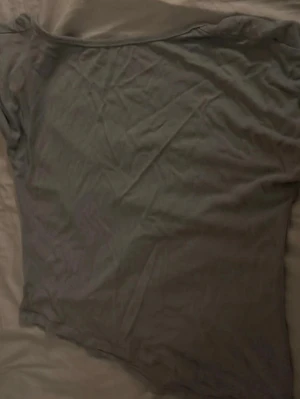 Grå offshoulder t-shirt - Säljer en enkel grå offshoulder t-shirt i mjukt material. Perfekt för dig som gillar en avslappnad och trendig stil. T-shirten har korta ärmar och en bred urringning som ger en cool vibe.