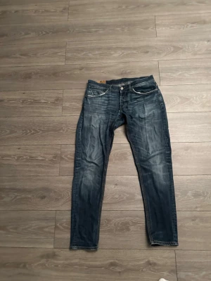 Blå Dondup jeans  - Säljer ett par blåa Dondup jeans med snygg tvättade detaljer. Jeansen har fem fickor, vita sömmar vid fickorna och knappgylf. Perfekta för dig som gillar en avslappnad men trendig stil.              Pris kan diskuteras vid snabb affär 