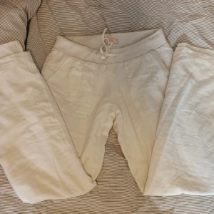 Vita linne byxor med snörning - Säljer ett par bekväma vita linne byxor med snörning i midjan. Byxorna har en avslappnad passform och är perfekta för en chill dag hemma. De har praktiska fickor framtill och en elastisk midja för extra komfort. Väldigt lowrise på. Mycket bra skick utan snörningen vilket är lite rufsigt.