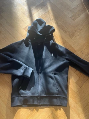 Svart hoodie med dragkedja från Polo - Svart hoodie från Polo Ralph Lauren. Passar M-L