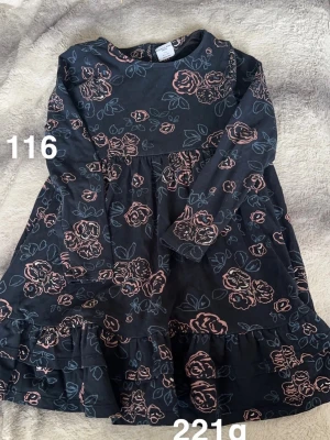 Mörkblå blommig klänning - Mörkblå klänning med rosa och ljusblått blommönster, lång ärm. Rund halsringning och mjukt, stretchigt tyg som känns bekvämt. Perfekt för dig som gillar romantiska detaljer och en avslappnad look.🌸 Fint använt skick. Storlek 116