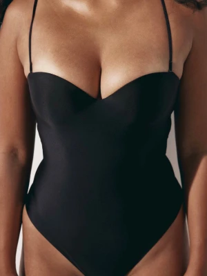 Svart shaping-body med tunna band - Svart shaping-body med tunna avtagbara axelband och vadderade kupor. Bodyn har en hjärtformad urringning och slät, stretchig passform som ger en smickrande siluett.                Använd 1 gång, tyvärr för liten i bysten för mig