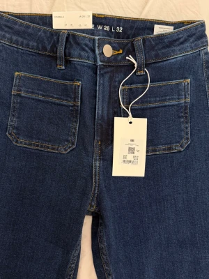 Helt nya oanvända mörkblå jeans flare bik bok - Helt nya och oanvända mörkblåa flare jeans från bikbok. Modellen heter camille och prislappen finns kvar. Väldigt smickrande modell. Storlek 26 i midjan med benlängd 32. Nypris 499kr