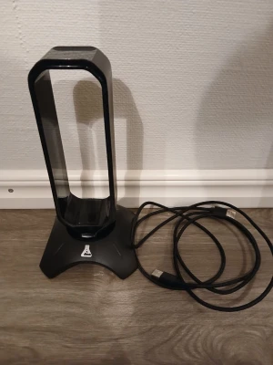 G-Lab RGB Headsetställ – Gaming - Snyggt och stabilt headsetställ från G-Lab (Stand Radon) med RGB-belysning. Perfekt för gaming-setupen och håller hörlurarna organiserade. ✔️ RGB-ljus ✔️ USB-driven ✔️ Fungerar felfritt ✔️ Bra skick (se bilder) OBS! Får inte med den rätta kartonge. Säljs då den inte längre används. Pris: 149 kr (öppen för rimliga bud) 