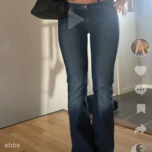 Blå bootcut jeans från Replay  - Snygga blå bootcut jeans från Red Card med klassisk femficksdesign och coola broderade detaljer på bakfickorna. Jeansen har låg midja och en lätt tvättad look. Materialet är mjukt denim i bomull. Perfekta för dig som gillar en retro vibe och vill sticka ut lite extra.
