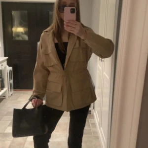 Beige overshirt från Ginatricot - En beige vårjacka/ cargo jacka. Superfin och oanvänd jacka från Gina i strl XS/S men lite oversized storlek Köpte förra året i butik för 600kr men kom aldrig till användning o säljer nu. Den har dock en liten ”uppljusad” fläck på baksidan, syns ej mycket och vet inte varifrån.💕💕