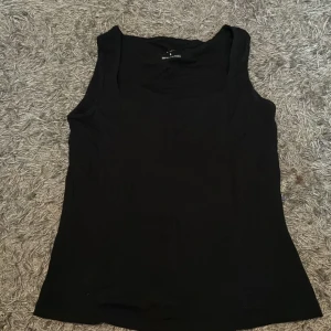 Svart linnetopp från 157, stl S - En klassisk svart linnetopp från 157 i storlek S. Toppen är ärmlös och har en enkel, rak passform som funkar till allt. Tillverkad i mjuk och stretchig viskosblandning för en skön känsla hela dagen.