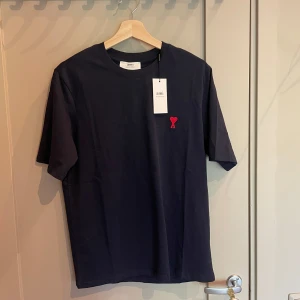 Ami Paris T-shirt - Säljer nu min helt nya ami Paris T-shirt i storlek S. Färgen svart/mörkblå. Riktigt stil ren och snygg. Tröjan är äkta. Tveka inte på att ställa frågor. 