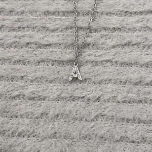 Refined Initial – A - Stilrent halsband i rostfritt stål. Litet 0,6 cm A-hänge som kan bäras på två sätt: slätt eller med gnistrande detaljer. Kedja 50 cm. Rost- och nickelfri.