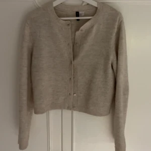Beige kofta från H&M med knappar - En superfin beige kofta från H&M. Kommer tyvärr inte till användning💖