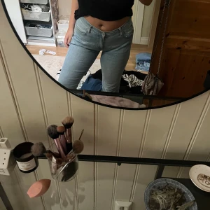 Ljusblå raka jeans midwaist - Säljer ett par ljusblå jeans med klassisk design och raka ben. Jeansen har midwaist-passform och är tillverkade i mjukt denimtyg som sitter snyggt på.