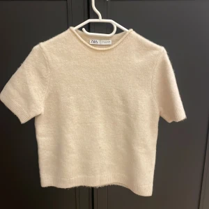 Beige stickad kortärmad tröja Zara - Supermjuk och stilren beige stickad tröja från Zara med korta ärmar och rund hals. Använd 1 gång 