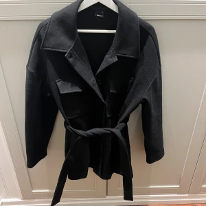 Kort Knyt kappa från Gina  - En jätte fin kortare kappa med band. Från Gina Tricot, storlek S