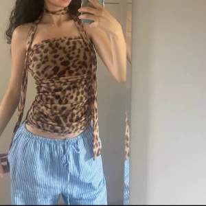 Leopardmönstrad tubtopp med scarf från Zara - Säljer en snygg leopardmönstrad tubtopp + tillhöranze scarf från Zara i brun och beige mesh. Toppen har en figurnära passform. Perfekt för dig som vill sticka ut med ett djurmönster och coola detaljer.