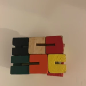  Fidget toy - Bilderna visar färgglada träklossar i olika färger, staplade och placerade i rad. Ingen bok eller text är synlig, endast leksaksliknande objekt. Passar dig som gillar kreativa och färgglada saker.