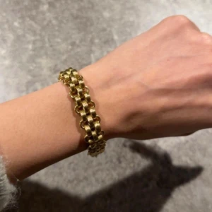 Brett guldarmband i kedjedesign - Använd men i jättebra skick. I rostfritt stål, tål vatten 