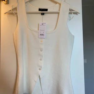 Slutsåld Vit ärmlös linnetopp från New Look - Säljer en stilren vit linnetopp från New Look i storlek 34. Toppen har fyrkantig ringning, knappar framtill och är ärmlös. Materialet är mjukt och stretchigt, perfekt för en clean och fräsch look. Passformen är normal och toppen är lätt att matcha med olika outfits. Helt ny! Och slutsåld på hemsidan. Nypris 390 kr💕
