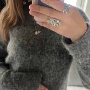 Mörkgrå fluffig stickad tröja - Supermjuk och fluffig mörkgrå stickad tröja med lång ärm och relaxed fit. Perfekt för lager-på-lager och riktigt cozy vibes. Enkel design utan mönster eller detaljer, passar dig som gillar basic men ändå vill ha något extra mysigt. Perfekt nu till hösten💞