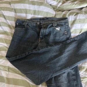 Jeans med broderade bakfickor Tippy - Mörkblå jeans från Tippy Concepts med snygga broderade detaljer i vitt på bakfickorna. Klassisk femficksmodell med raka ben och normal passform. Jeansen har dragkedjegylf och tydliga kontrastsömmar för en cool look.