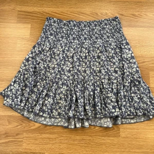 Blommig blå volangkjol - Säljer min blåblommiga kjol från lager 157. Kommer inte till användning längre, men är väldigt fin! Bra skick, inte använd så mycket. Storlek s men passar även xs. 