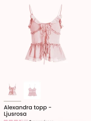 Ljusrosa volang topp med snörning - Supersöt ljusrosa topp med tunna axelband, volanger och snörning framtill. Toppen har en luftig och flowy passform med flera lager volangdetaljer och små rysch längs bröstet. Perfekt för sommarens alla tillfällen. Helt oanvänd.