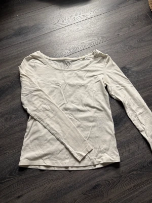 Vit långärmad topp i bomull - En enkel och stilren vit långärmad topp med rund halsringning. Tillverkad i mjuk bomull som känns skön mot huden. Perfekt att matcha med jeans eller kjol för en clean look.
