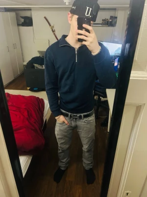 Mörkblå half zip sweatshirt - Mörkblå sweatshirt med half zip och hög krage. Tröjan har långa ärmar och ribbade muddar vid ärmslut och nederkant. Perfekt för dig som gillar en enkel och clean stil. Passar till både jeans och mjukisbyxor.