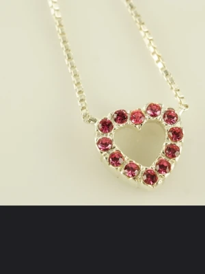 Halsband med hjärthänge i silver - Sött halsband i äkta silver (925) med ett hjärthänge dekorerat med rosa stenar. Kedjan är tunn och smidig, och hjärtat har en öppen design med gnistrande detaljer som verkligen poppar. Perfekt accessoar för att lyfta vilken outfit som helst.