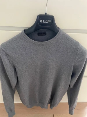 Grå stickad tröja från Stenströms - En klassisk grå stickad tröja från Stenströms med rund halsringning och långa ärmar. Perfekt basplagg i garderoben, enkel att matcha och har en mjuk känsla. Passar till både jeans och chinos. Storlek S