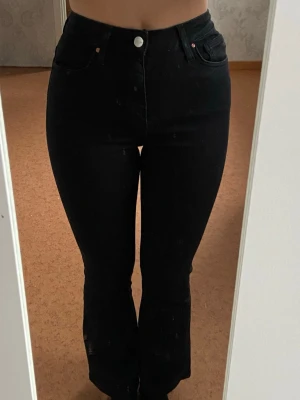 Svarta Peachy Flare byxor S/31 - Säljer ett par svarta Peachy Flare byxor från JP i storlek S/31. Byxorna har hög midja och utsvängda ben, vilket ger en snygg siluett. Klassisk femficksmodell med knapp och dragkedja framtill. Perfekta för dig som gillar en trendig och bekväm look. 🩷