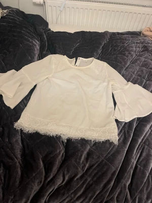 Vit spets blus från Lindex - Vit spets blus från Lindex i storlek 146. Blusen har vida ärmar och knappar baktill. Har små fläckar men syns knappt. Funderingar? Skriv till mig💕