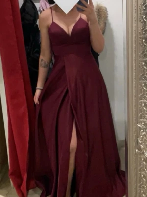 Vinröd långklänning med snörning -  Säljer min vinröda balklänning 🤍 Använd en gång och i superbra skick, i princip som ny. Klänningen har en snygg slits och kommer med skyddspåse så den kan förvaras fint.  Storlek 42, passar dig som vanligtvis har M eller L. Jag är 177 cm lång och klänningen har bra längd.  Nypris var 3 500 kr, säljer den för 1800.  Skriv gärna om du vill ha fler bilder eller info! 