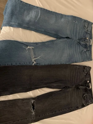 Två par jeans med slitningar - Säljer två par jeans, ett par ljusblå och ett par mörk gråa Båda har trendiga slitningar vid knäna. ( finns ej att köpa i butik längre)