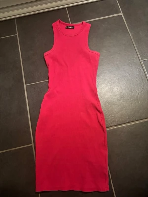 Klänning - Rosa klänning perfekt för sommaren! Går ner över höfterna. 