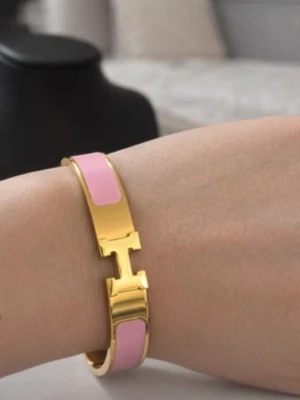 H-armband  - Säljer ikoniska H-armband i guldpläterad metall med emaljdetaljer. Finns i svart, vit, röd, rosa, gråblå och orange. Snyggt H-spänne framtill och stilren design som lyfter din outfit. Perfekt accessoar för dig som gillar lyx och färg.