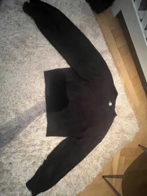 Svart stickad tröja från H&M Divided - Mysig svart stickad tröja från H&M Divided i storlek S. Tröjan har en enkel, klassisk design med rund hals och långa ärmar. Perfekt att slänga på sig när det är kyligt ute och funkar till det mesta i garderoben. Säljer då den är för liten!
