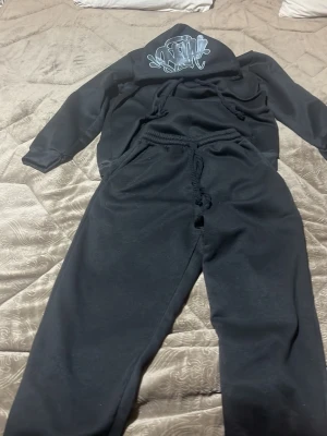 Syna world tracksuit  - Helt svart syna world tracksuit me rop snöre med en baggy fit 