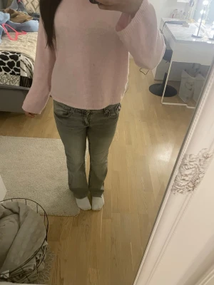Grå bootcut jeans med fickdetaljer - Säljer ett par grå jeans med bootcut passform och snygga fickdetaljer bak med knappar. Jeansen har normal midja och raka ben med lätt utsvängning. Materialet är klassisk jeans och färgen är en ljusgrå tvätt. Perfekta till sneakers eller boots. Förkortade till 150-160 cm ❤️.