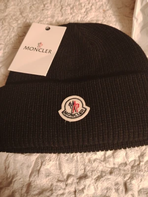 Svart Moncler mössa  - Säljer en svart moncler mössa som är oanvänd 