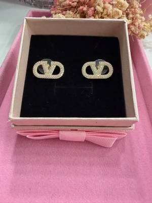 Eleganta örhängen  - Mycket vackra örhängen i rostfritt stål, pläterade med 18 karat guld. Dekorerade med gnistrande rhinestone-kristaller som ger ett exklusivt och elegant utseende. Allergivänliga och skonsamma mot huden – perfekta även för känsliga öron.  ✔ Rostfritt stål ✔ 18K guldplätering ✔ Allergivänliga ✔ Hållbara och behåller sin glans  💛 Stilrena örhängen som passar både till vardag och fest.