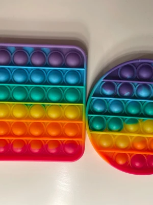 Pop it, fidget toy🌈 - Regnbåge pop it. Använda men i bra skick! Två stycken i ett packet. Ca 13cm åt båda håll på båda. 