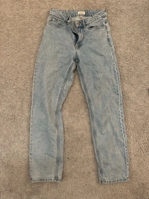 Ljusblå raka jeans från Lindex - Säljer ett par ljusblå jeans från Lindex med klassisk femficksdesign och raka ben. Jeansen har normal passform och är tillverkade i slitstarkt. Perfekta till en avslappnad look och funkar året runt.