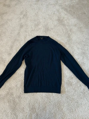 Mörkblå tunn tröja, från Massimo dutti - En stilren mörkblå stickad tröja från Massimo dutti. Tröjan har rund halsringning och långa ärmar. Perfekt för lager på lager och enkel att matcha med olika outfits.